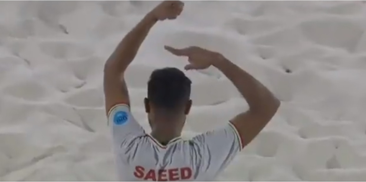 Il calciatore iraniano di beach soccer che esulta facendo il simbolo della protesta